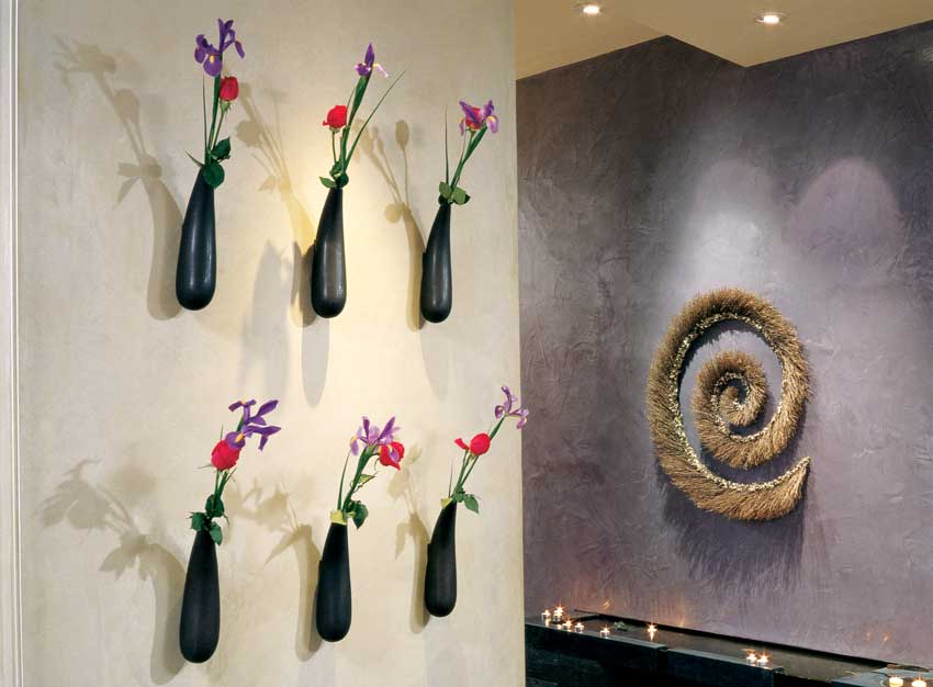 Sandra calls this her “Living Wall.” She displays seasonal blooms in these gracefully sculpted and mounted vases positioned just adjacent to the bubbling serenity of her entryway fountain.